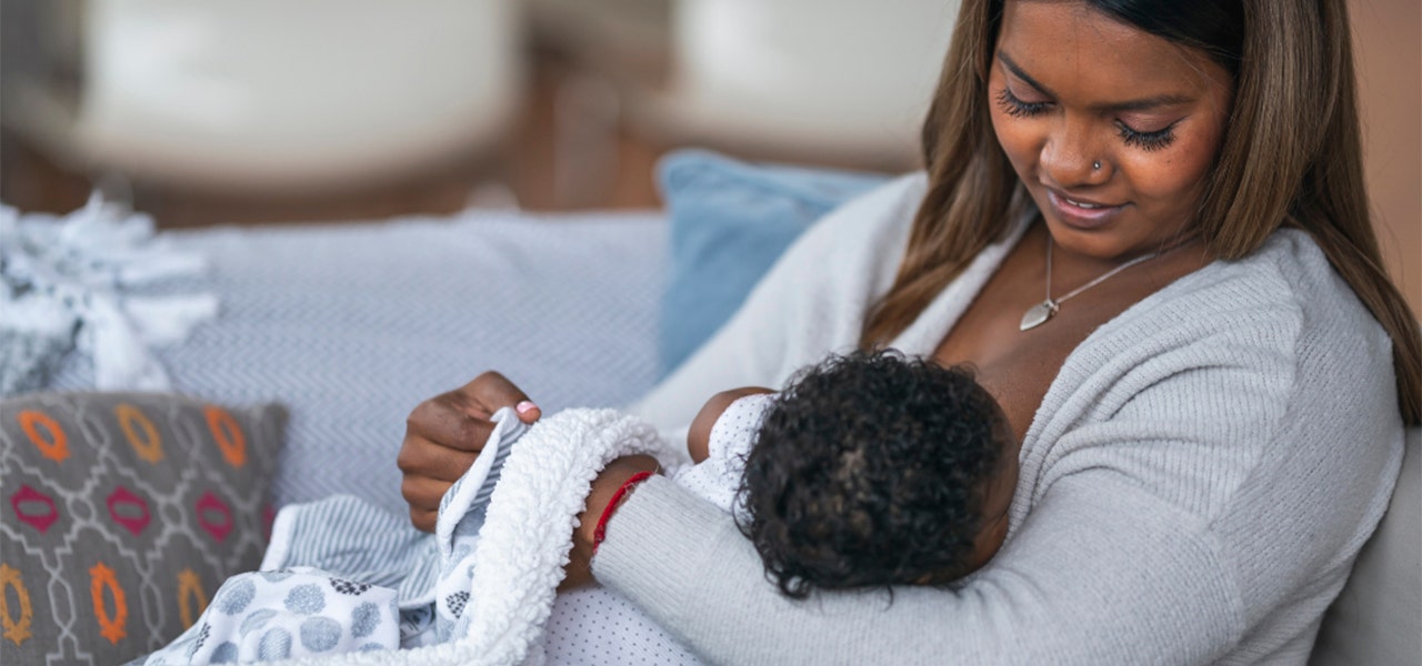 Mother smiling down at Baby while nursing