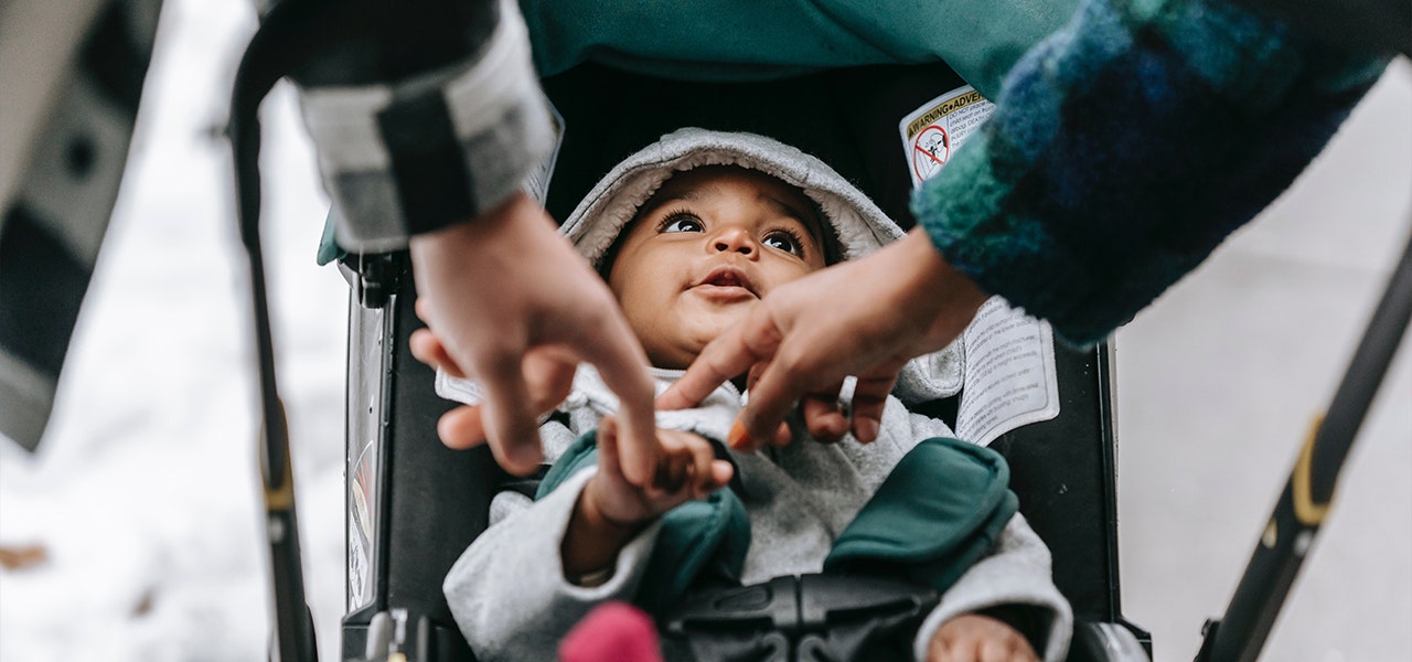 Parents taking their baby on a walk in the stroller during cold and flu season