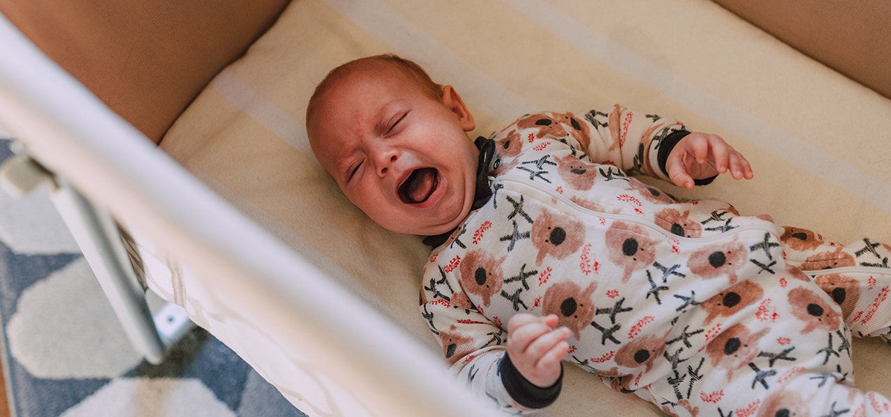 Baby awake and crying in their crib