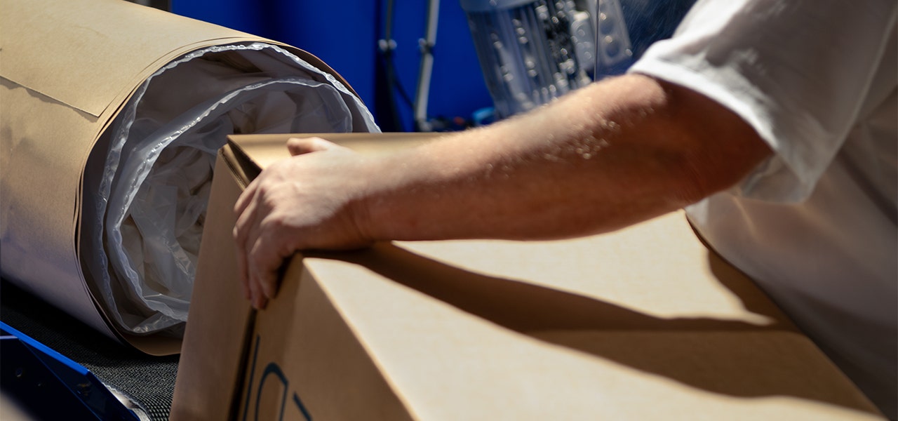 Naturepoedic factory working boxing up a mattress roll-packed in kraft paper