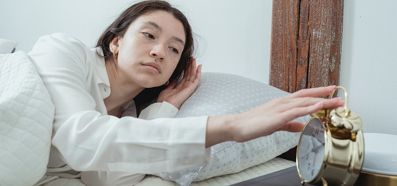 Woman waking up on time and turning off her alarm