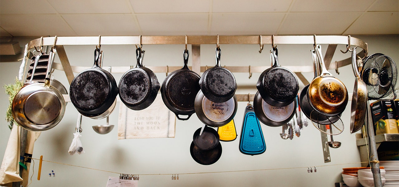 PFAS-free pots and pans hanging in a kitchen