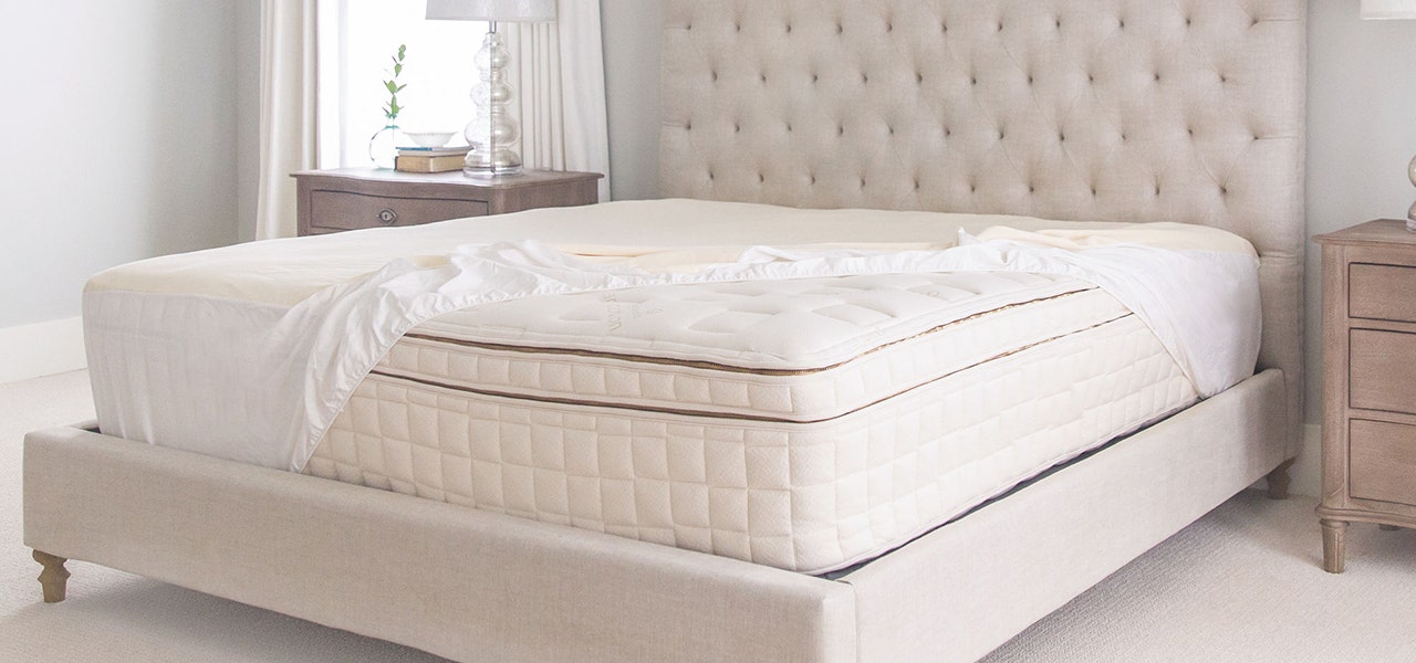 Clean, fresh bed with an organic mattress and waterproof mattress pad