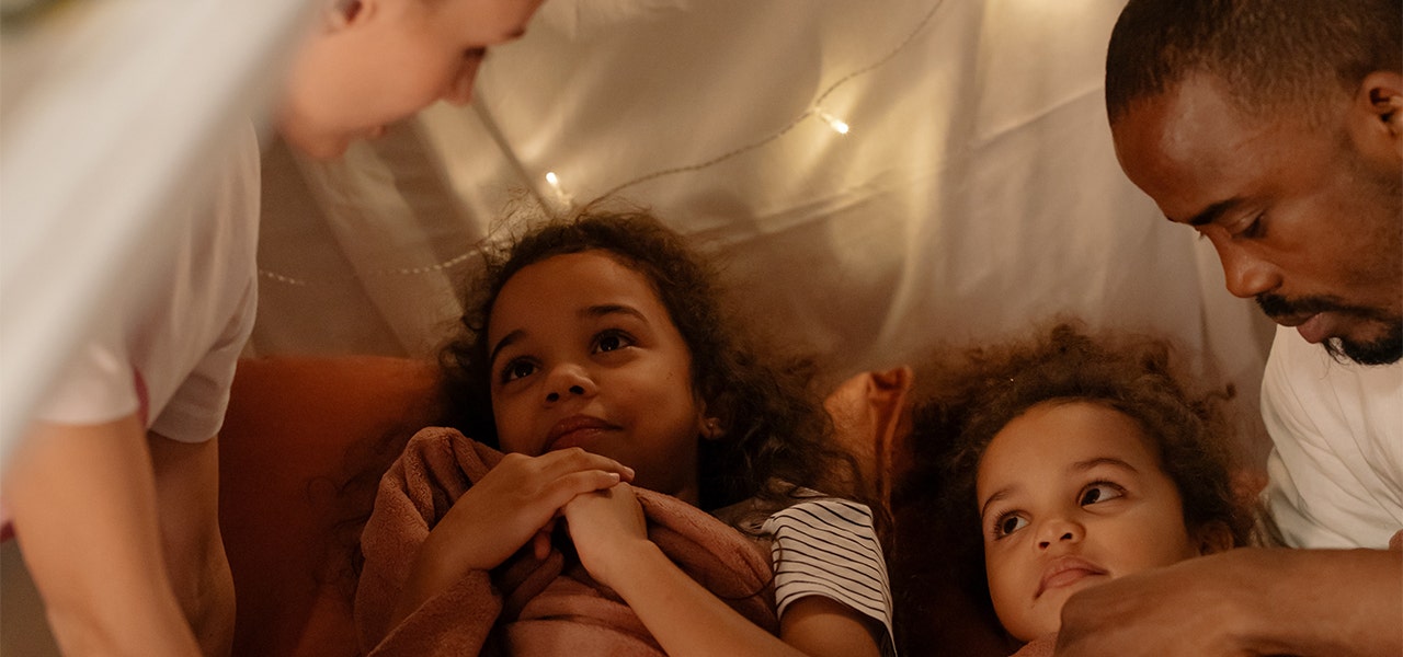 Parents tucking their excited kids into bed over the holidays