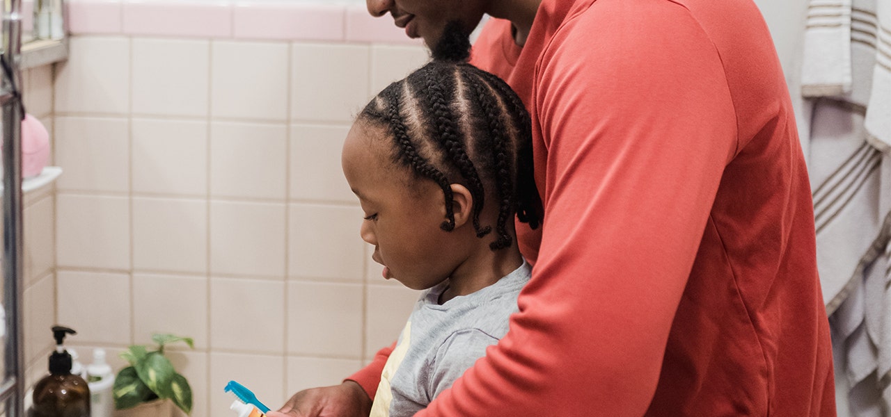 Father helping his daughter brush her teeth at bedtime