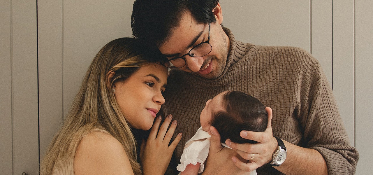 Parents smiling proudly at sleeping infant