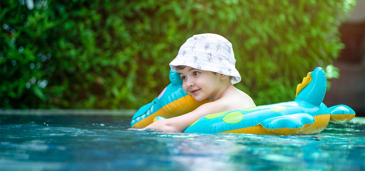 Smiling young boy floating in a lake on an inner tube