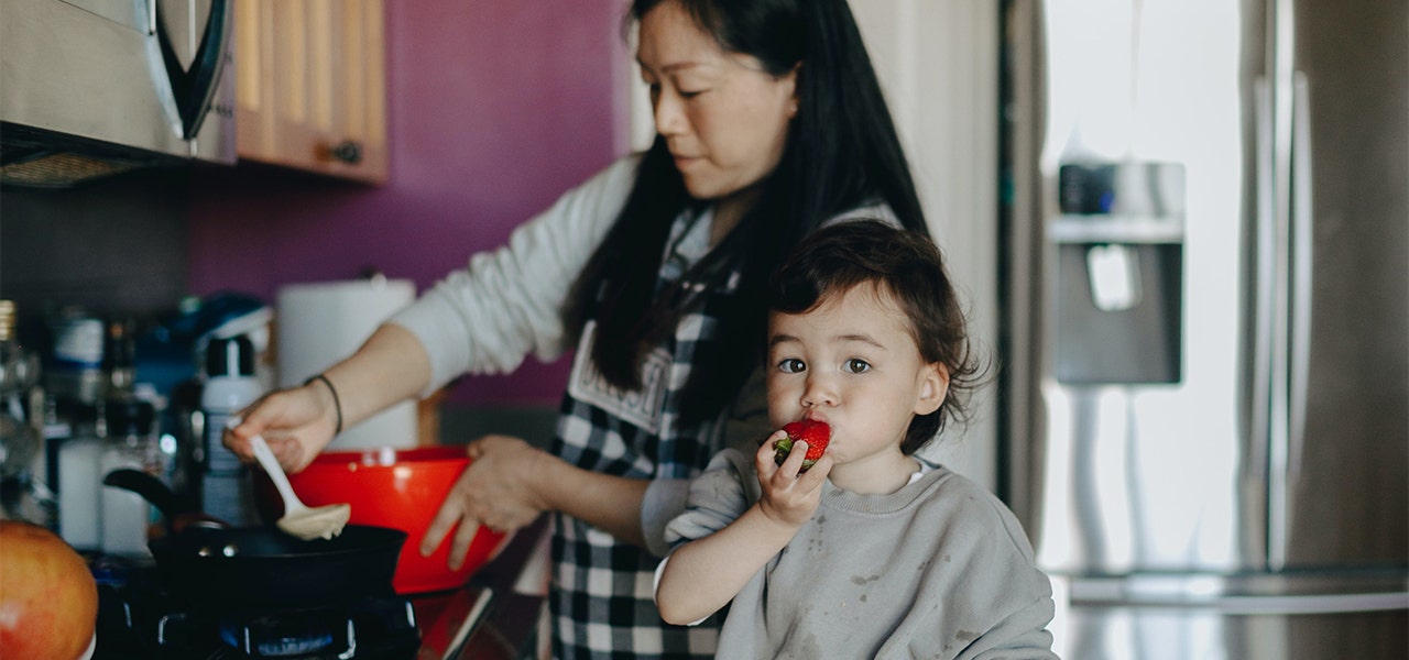 Mother and small child cooking together with fresh organic ingredients