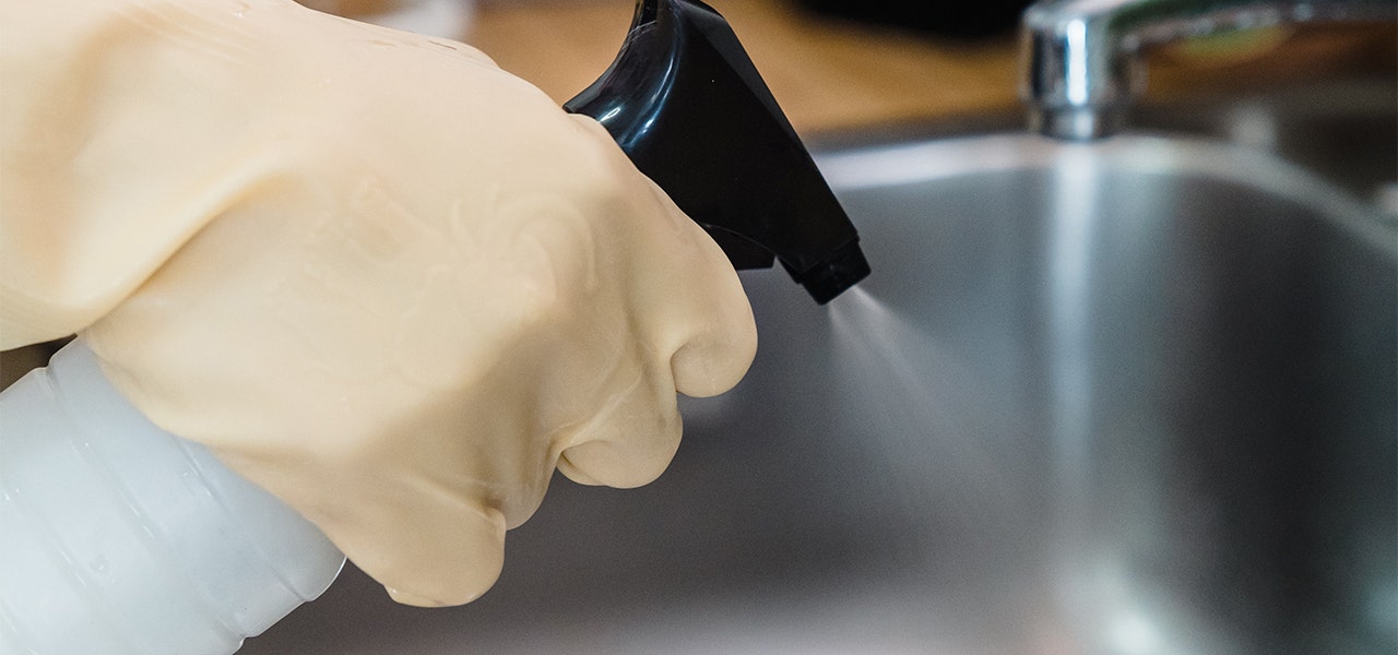 Person spraying their sink with a DIY cleaning solution