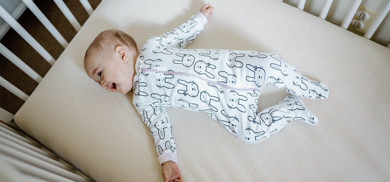 baby laying on organic crib mattress