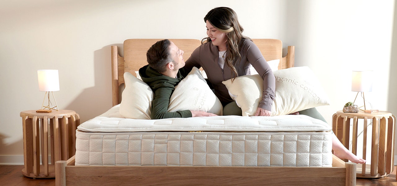 Couple hanging out on their Naturepedic EOS Classic Mattress