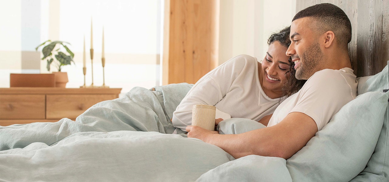 couple lounging in organic linen sheets and bedding