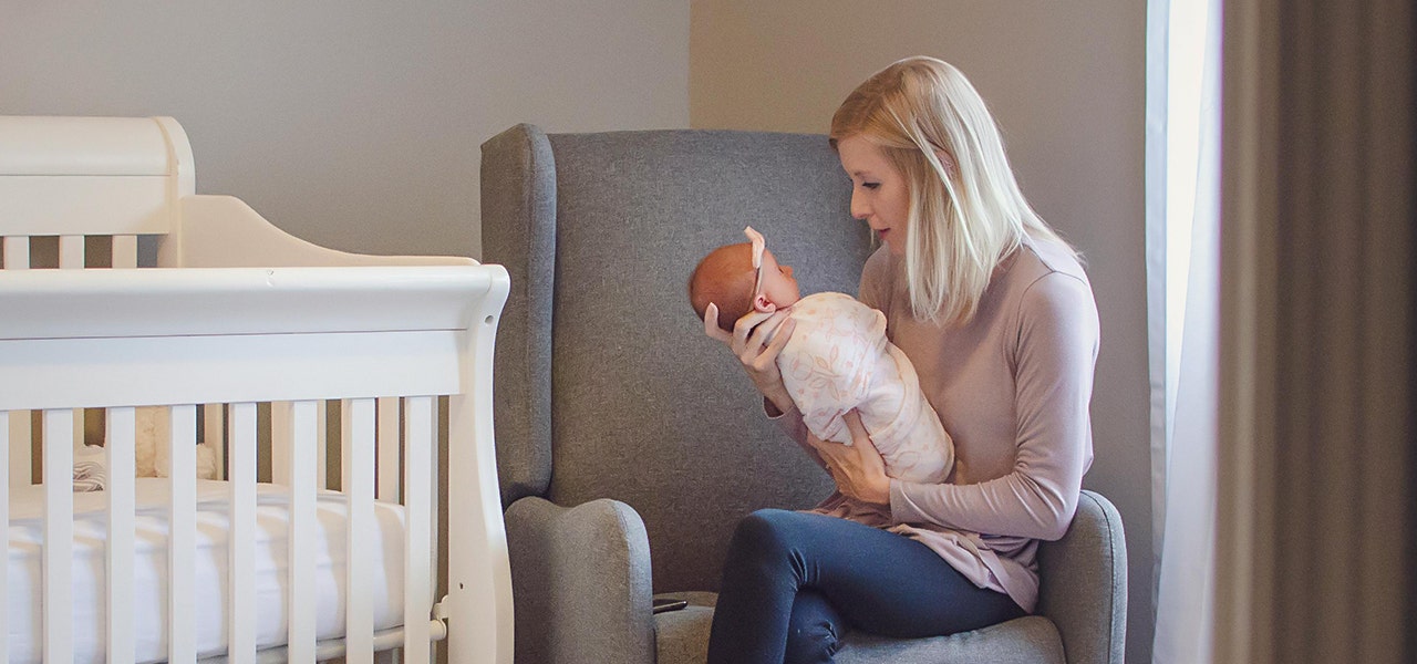 parent holding baby in nursery
