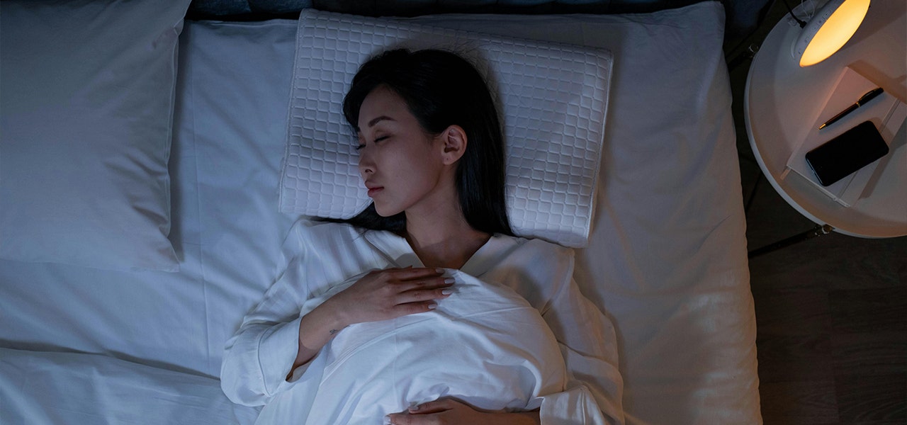 person sleeping on back in bed