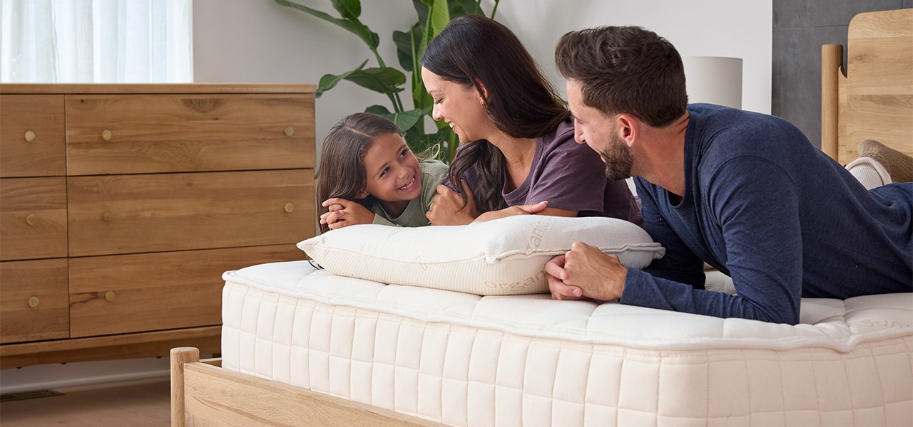 family of three laying on a naturepedic organic mattress